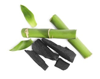 Photo of Fresh bamboo and charcoal on white background, top view