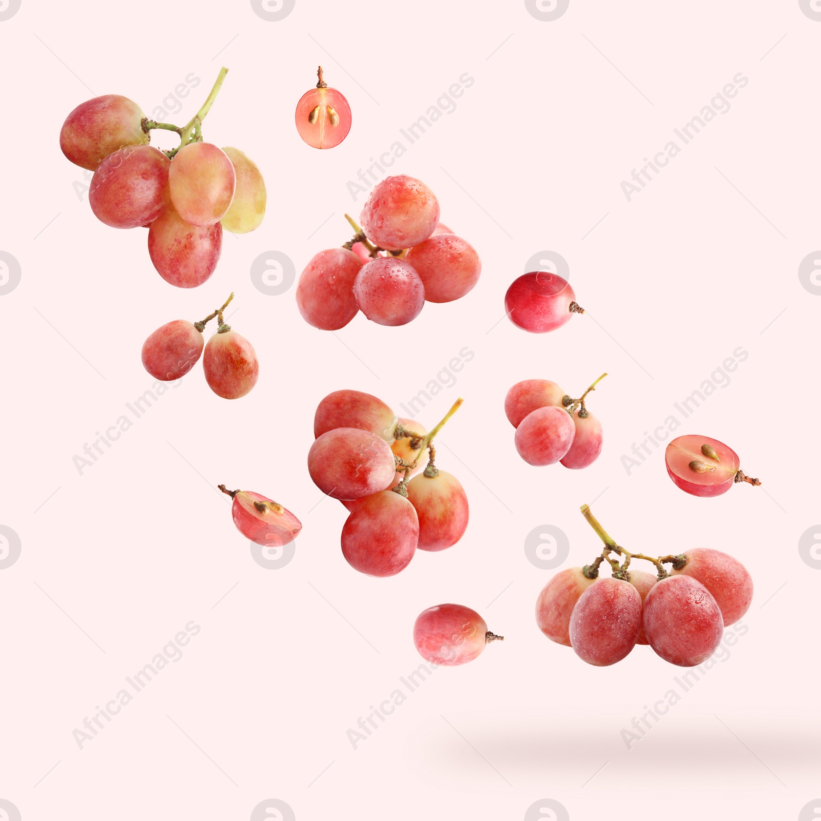 Image of Fresh grapes in air on light red background