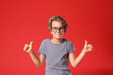 Photo of Cute little boy in casual outfit on red background