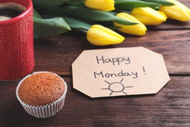 Photo of Happy Monday message, aromatic coffee, cupcake and tulips on wooden table