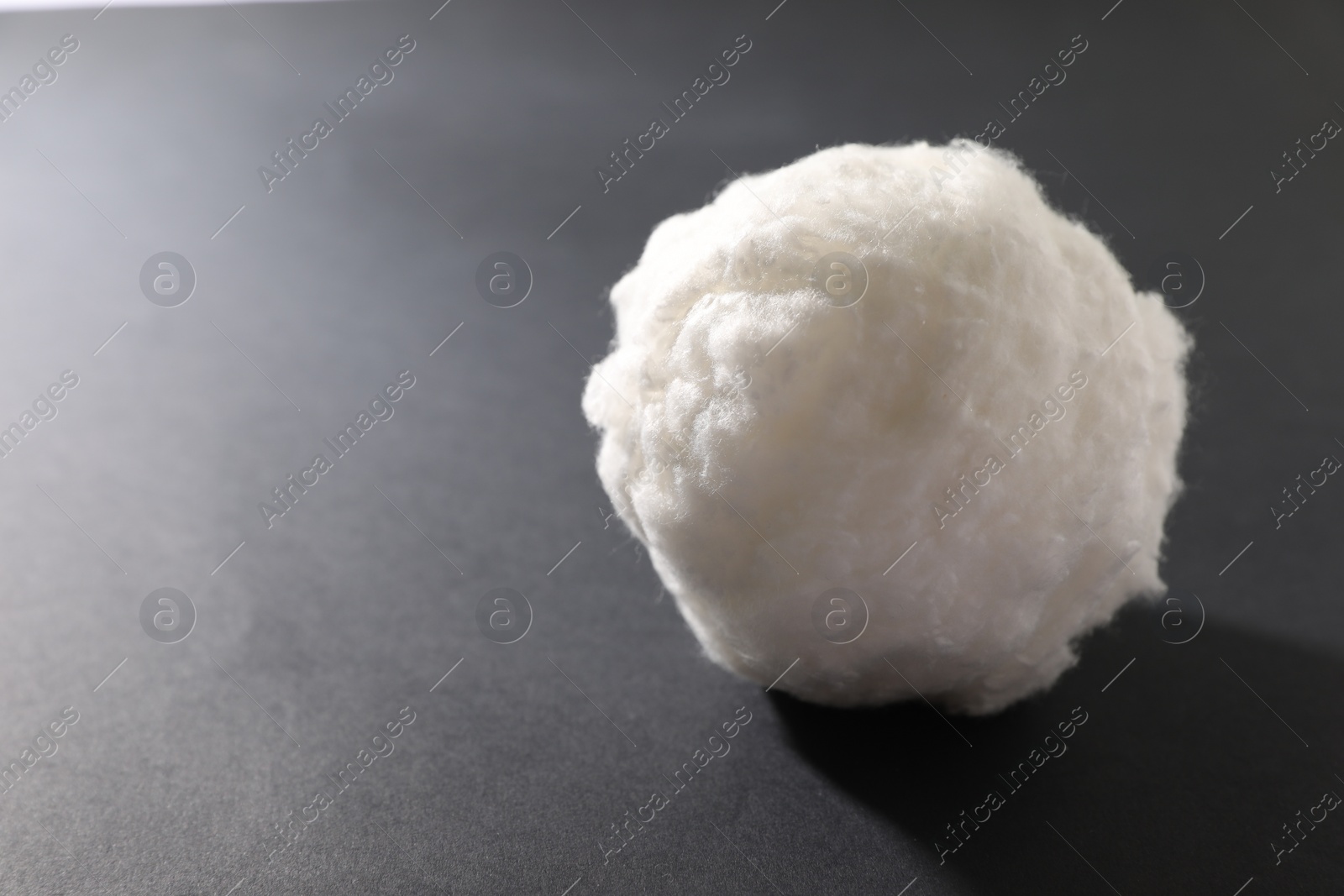 Photo of Ball of clean cotton wool on grey background, space for text