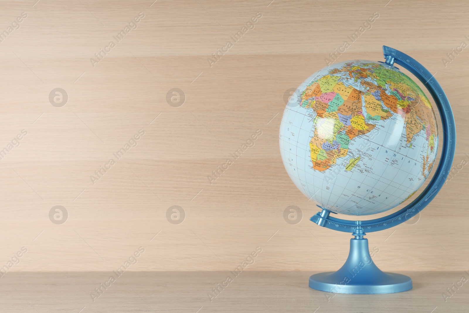 Photo of Plastic model globe of Earth on wooden table, space for text. Geography lesson