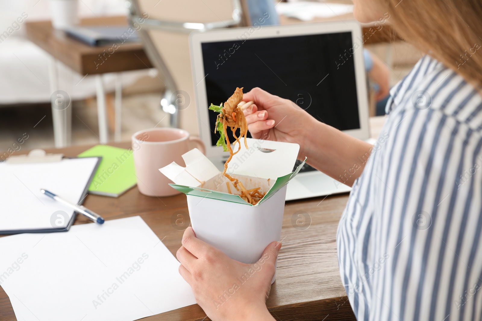 Photo of Office employee having noodles for lunch at workplace, closeup. Food delivery