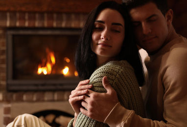 Photo of Lovely couple near fireplace at home. Winter vacation