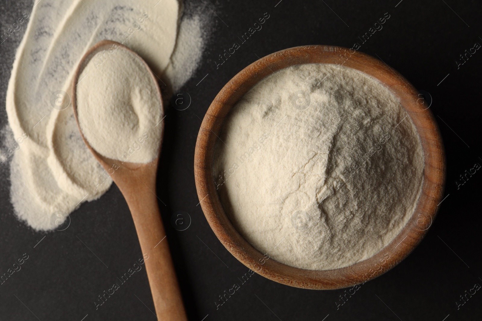 Photo of Bowl and spoon of agar-agar powder on black background, flat lay