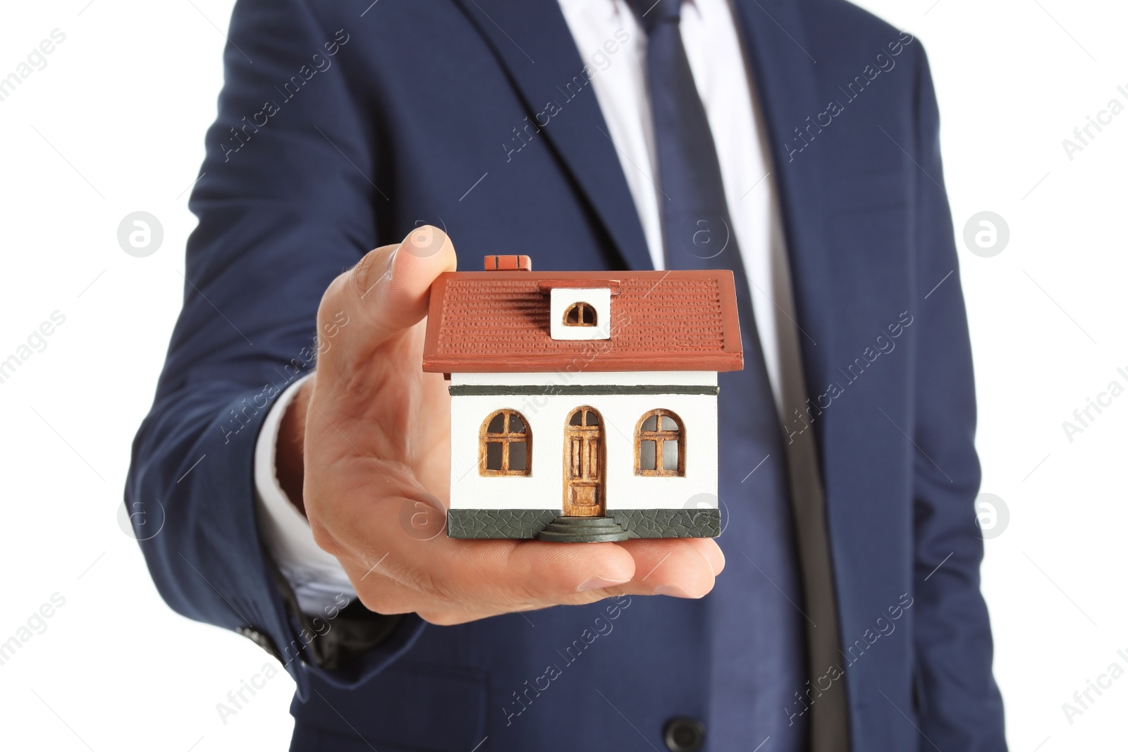 Photo of Real estate agent holding house model on white background, closeup