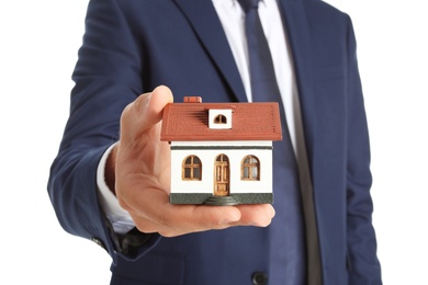 Real estate agent holding house model on white background, closeup