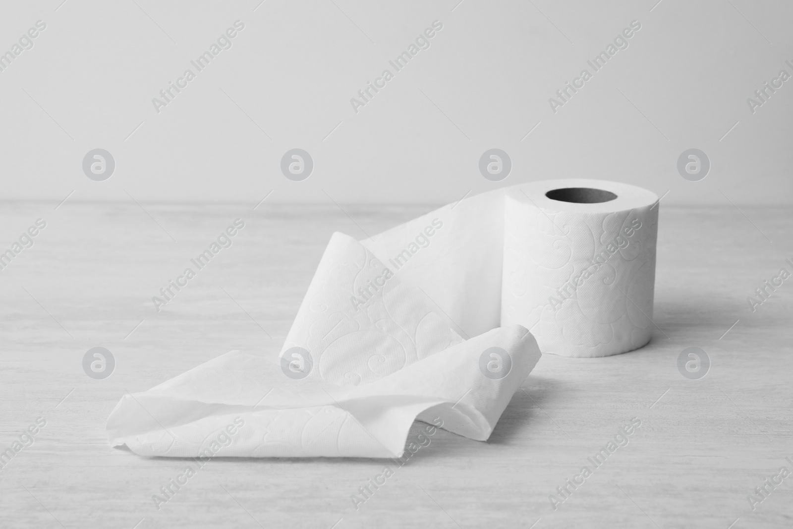 Photo of Soft toilet paper roll on light background