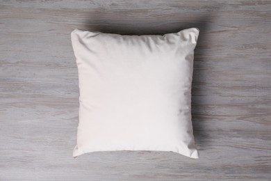 Blank soft pillow on wooden background, top view