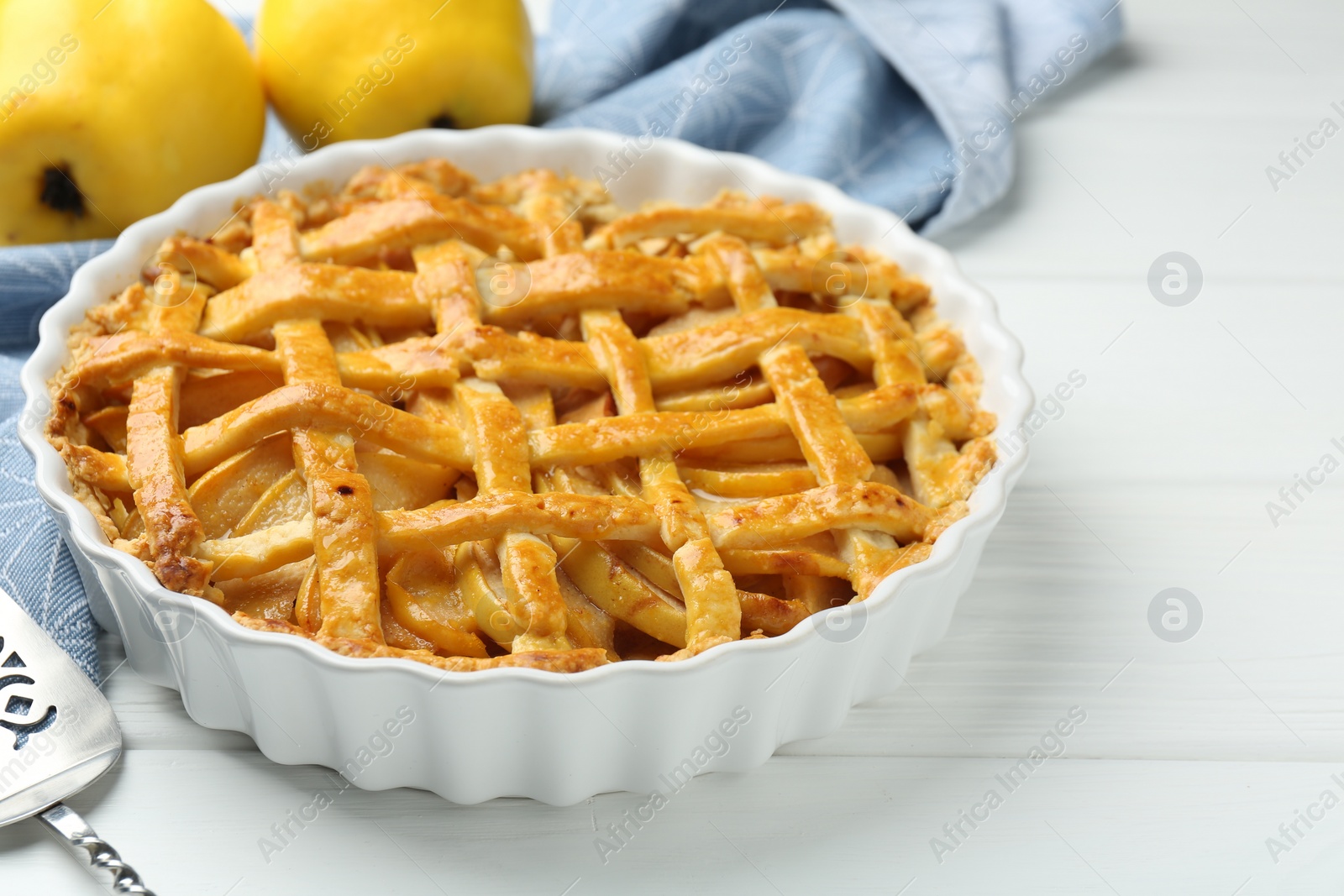 Photo of Tasty homemade quince pie on white wooden table, closeup