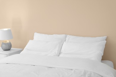 Photo of White soft pillows on cozy bed in room