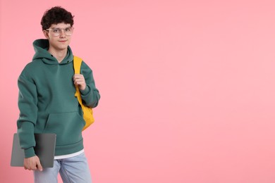 Photo of Portrait of student with backpack and laptop on pink background. Space for text