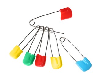 Photo of New colorful safety pins on white background