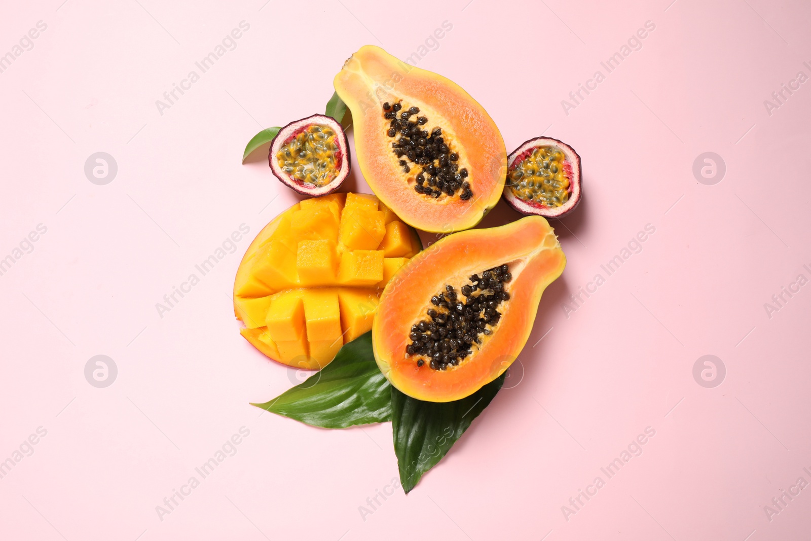 Photo of Fresh ripe papaya and other fruits on pink background, flat lay