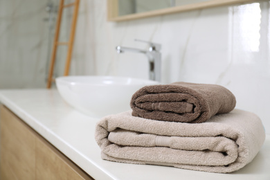 Photo of Stack of clean towels on bathroom countertop. Space for text