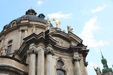 LVIV, UKRAINE - MAY 2, 2022: Beautiful Dominican Cathedral against blue sky, low angle view