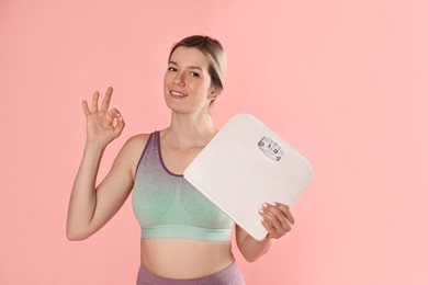 Photo of Beautiful woman with scales showing OK gesture on pink background