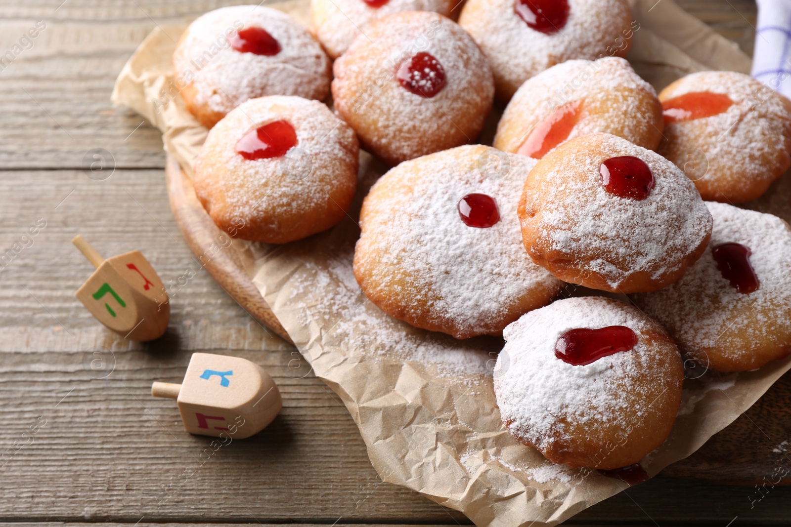 Photo of Hanukkah donuts and dreidels on wooden table