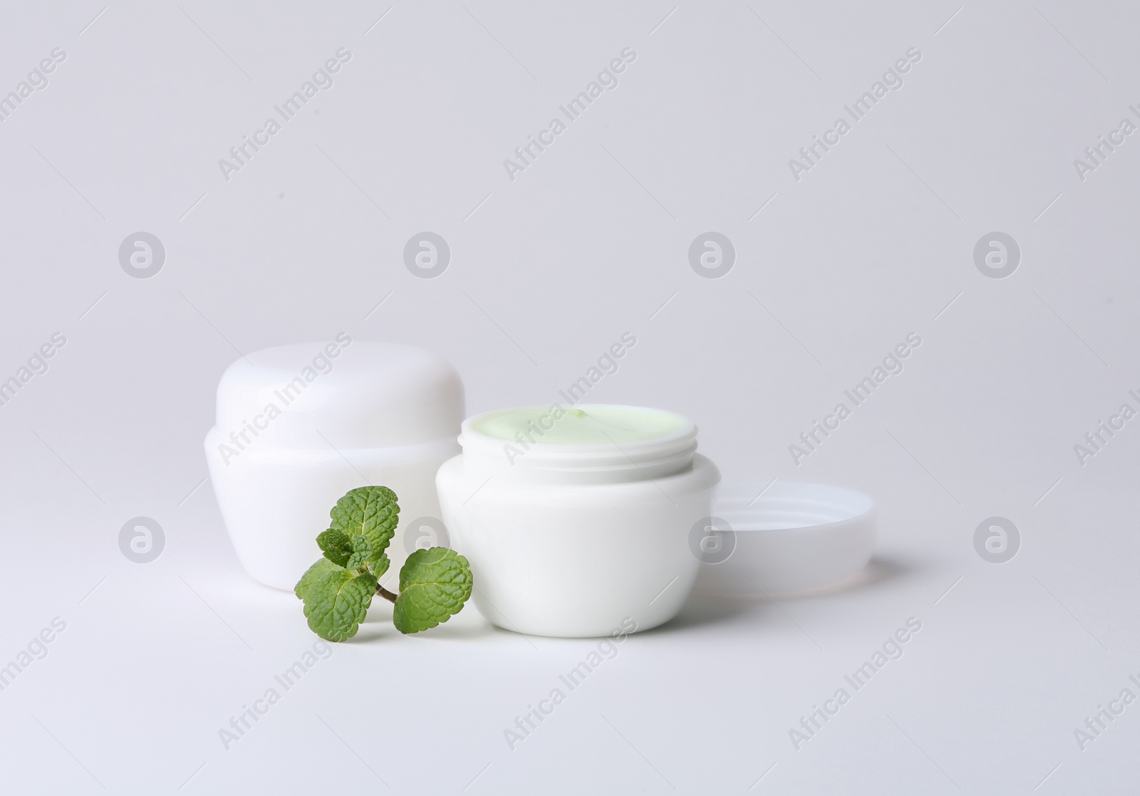 Photo of Jars of body cream on light background