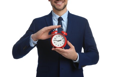 Photo of Happy businessman holding alarm clock on white background, closeup. Time management