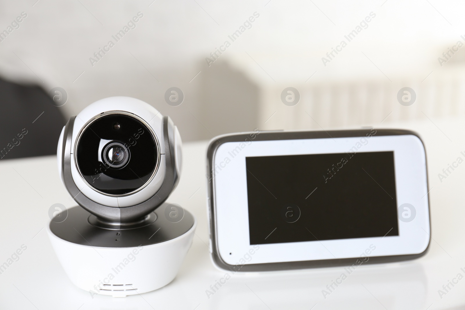 Photo of Baby monitor with camera on table in room. Video nanny