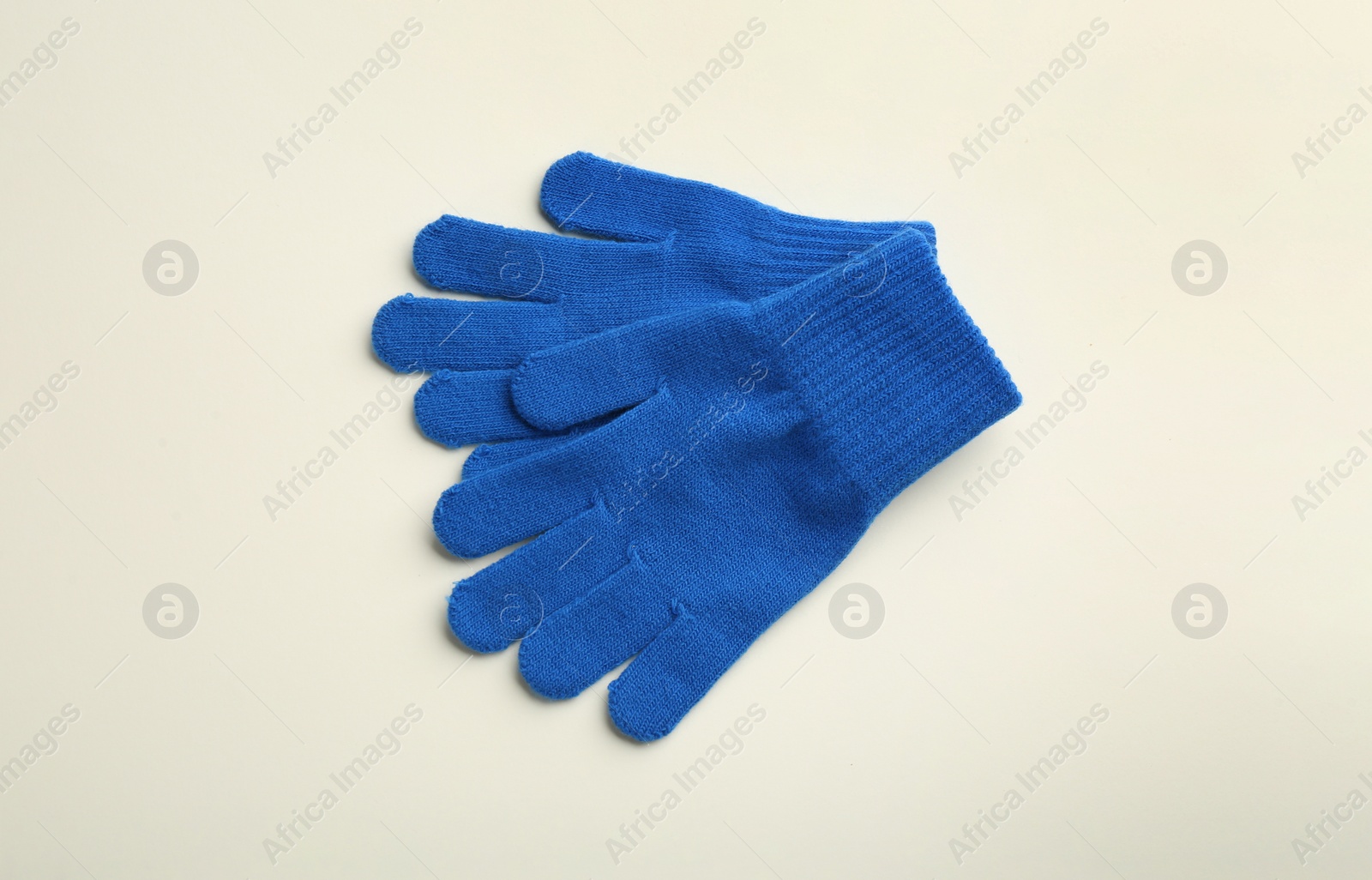 Photo of Pair of stylish woolen gloves on beige background, flat lay