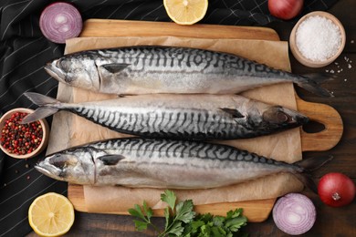 Tasty salted mackerels and products on wooden table, flat lay