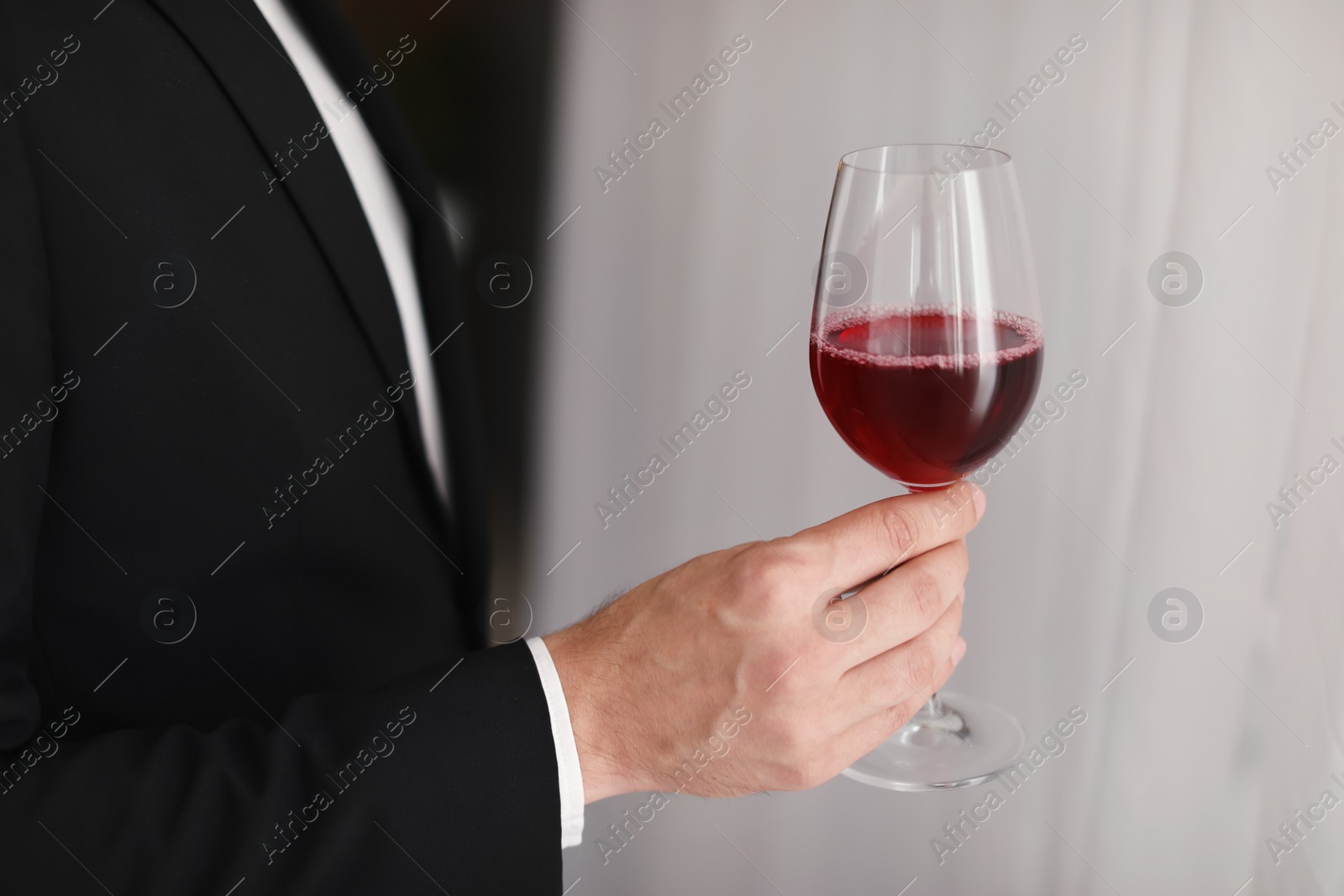 Photo of Young man with glass of wine indoors