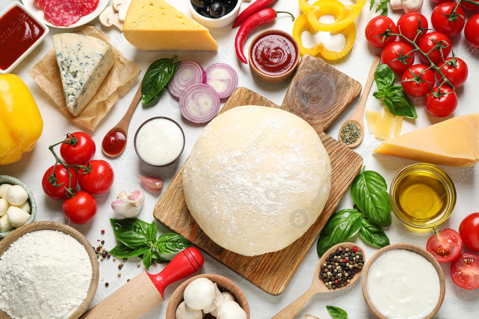 Photo of Flat lay composition with dough and fresh ingredients for pizza on white wooden table