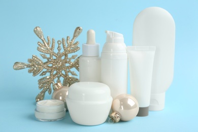 Beautiful composition with cosmetic products on light blue background. Winter care