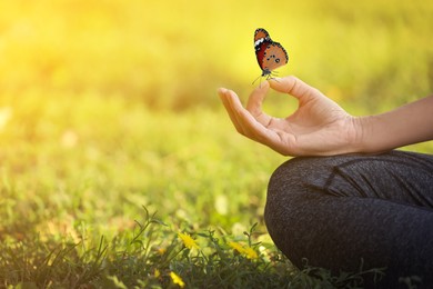 Woman meditating on green grass, closeup. Space for text