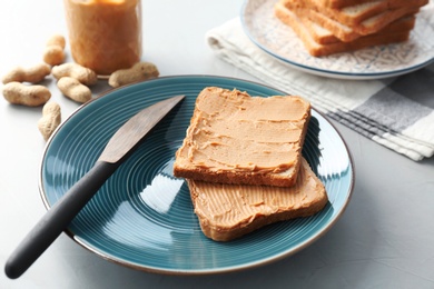 Tasty toasts with peanut butter on plate