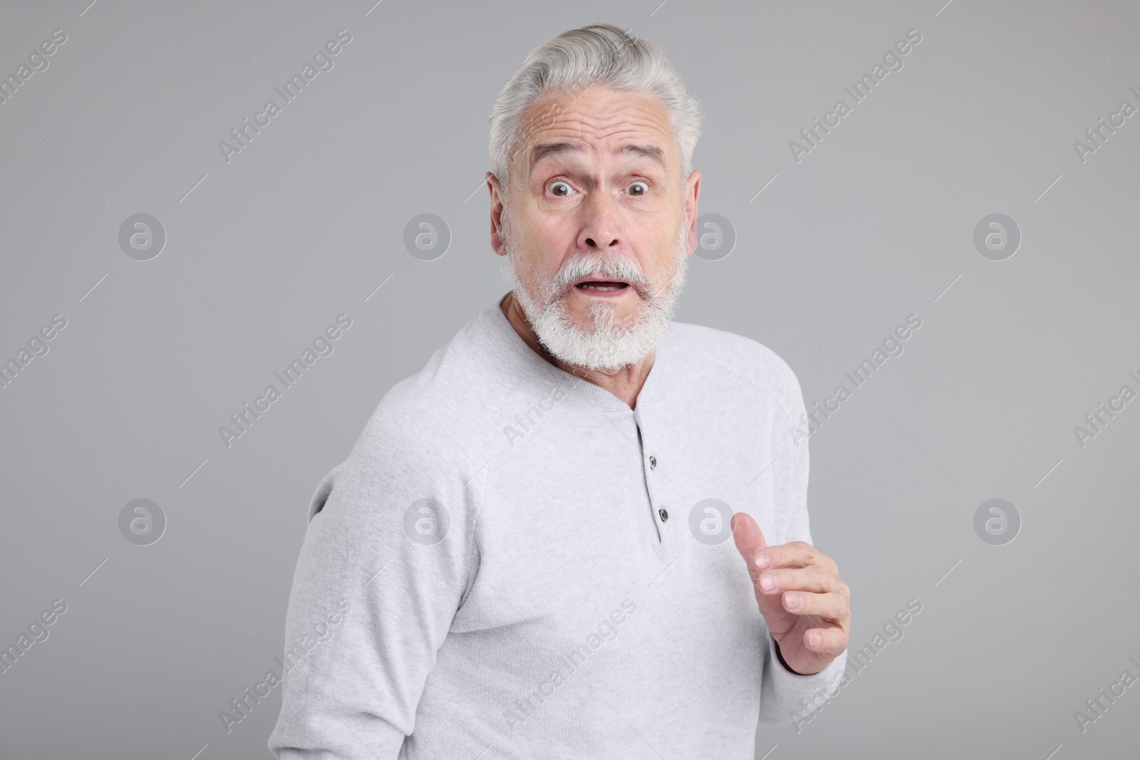 Photo of Portrait of surprised senior man on grey background