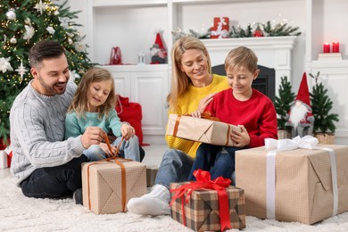 Photo of Parents and their children opening Christmas gifts at home