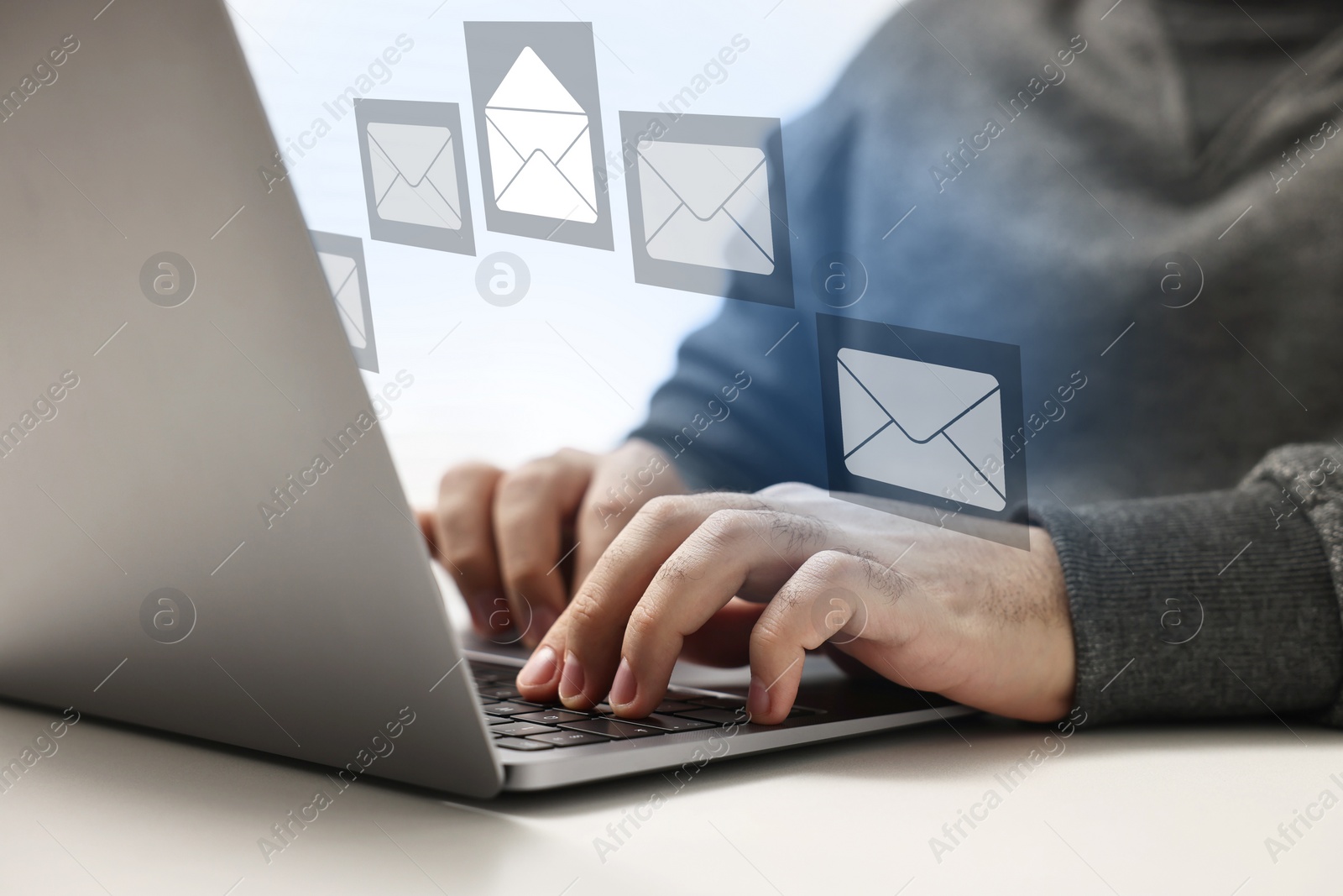 Image of Email. Man using laptop at table, closeup. Letter illustrations over device