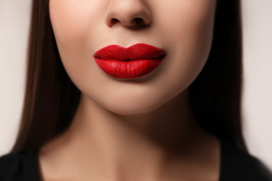 Photo of Beautiful woman with red lipstick on light background, closeup