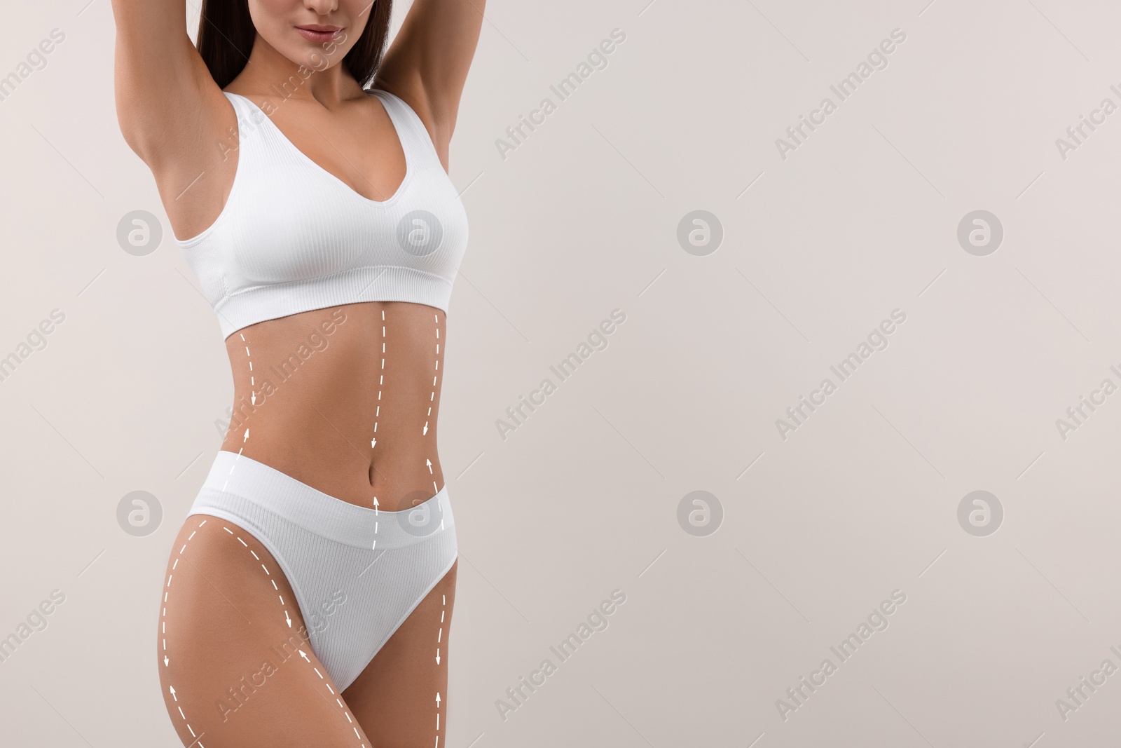 Image of Woman showing her beautiful figure on white background, closeup. Space for text. Cosmetic treatment lines on her body