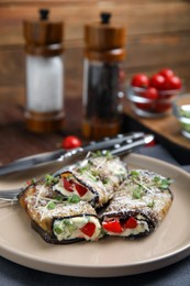 Delicious baked eggplant rolls served on table, closeup