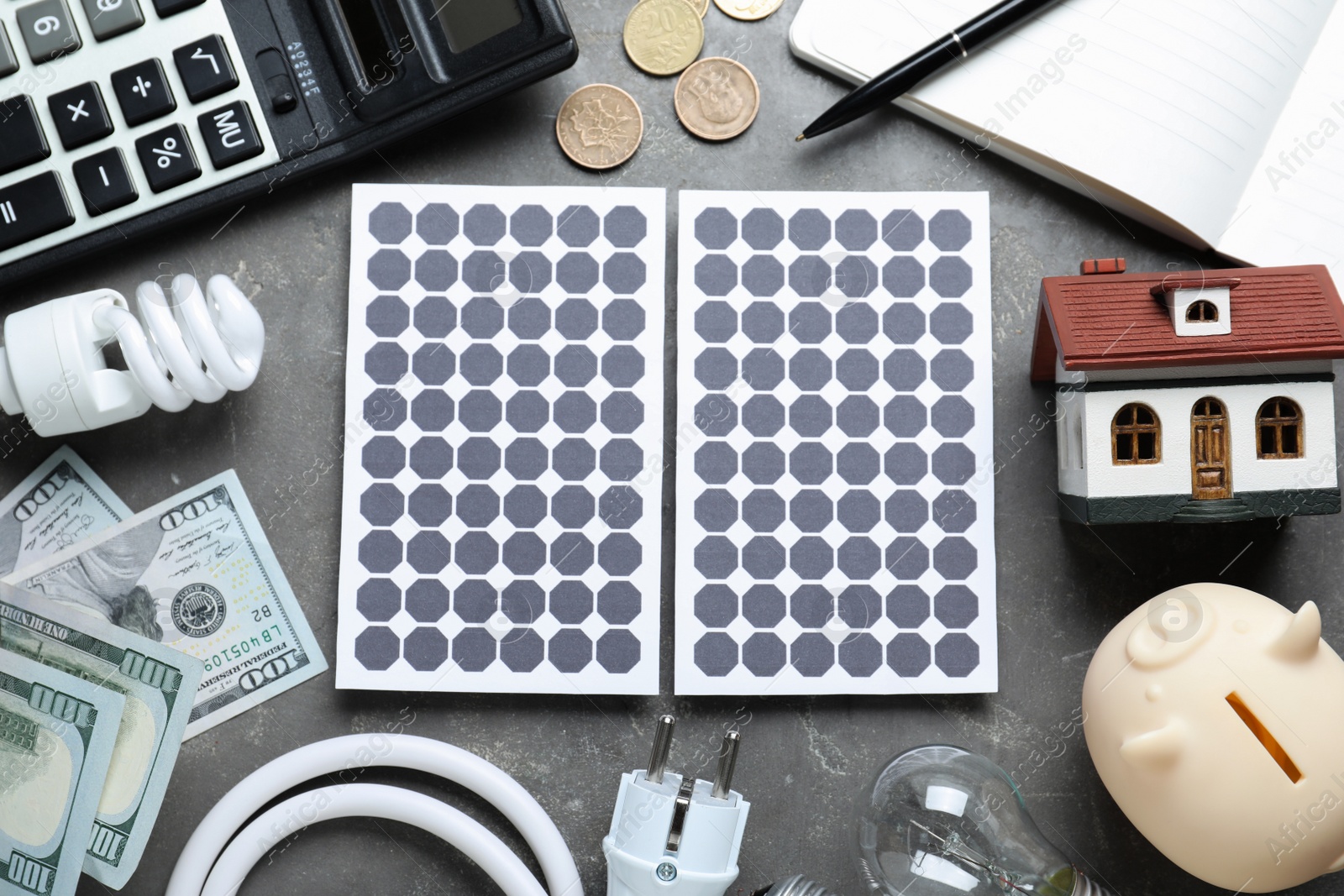 Photo of Flat lay composition with solar panels and house model on grey table