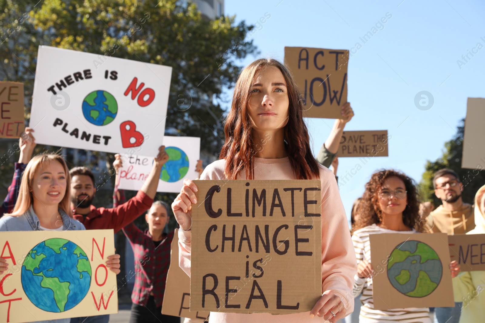 Photo of Group of people with posters protesting against climate change on city street