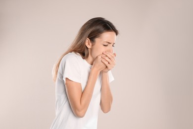 Woman suffering from nausea on beige background. Food poisoning