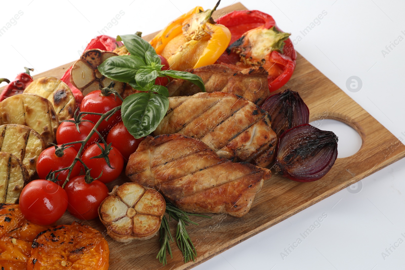 Photo of Wooden board with tasty grilled vegetables, meat, rosemary and basil isolated on white