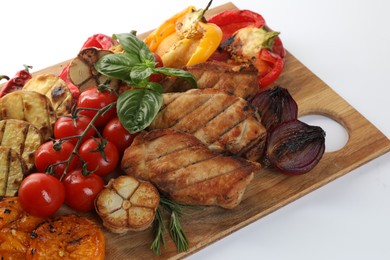 Photo of Wooden board with tasty grilled vegetables, meat, rosemary and basil isolated on white