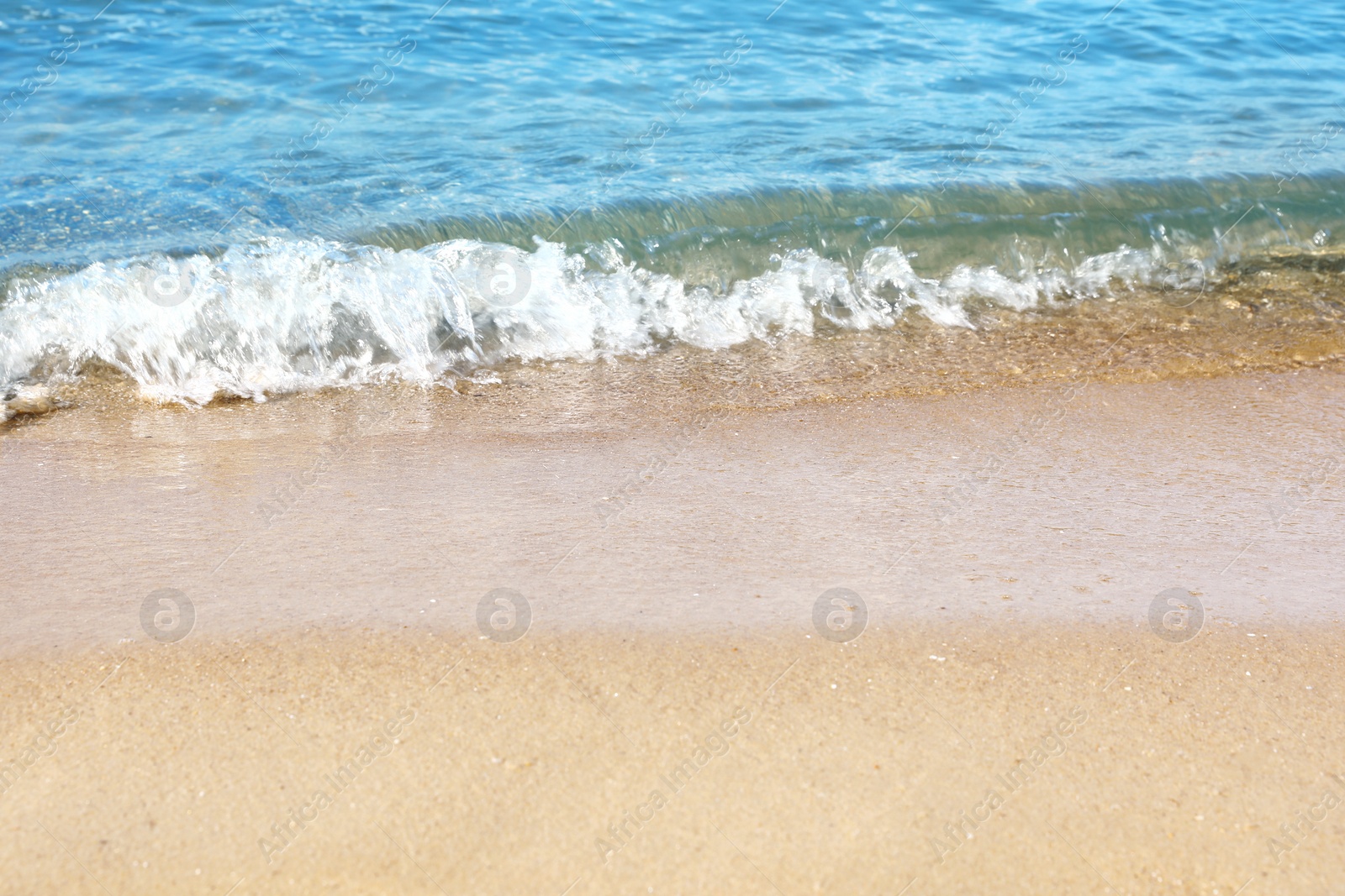 Photo of View of sea water and beach sand on sunny day