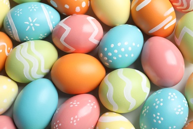 Photo of Many beautiful painted Easter eggs as background, top view