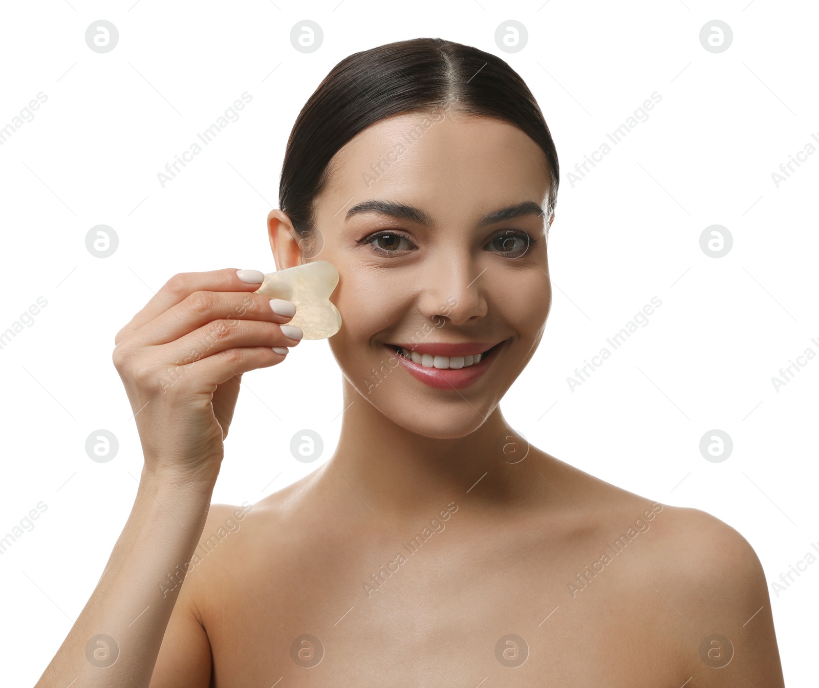 Photo of Beautiful young woman doing facial massage with gua sha tool on white background