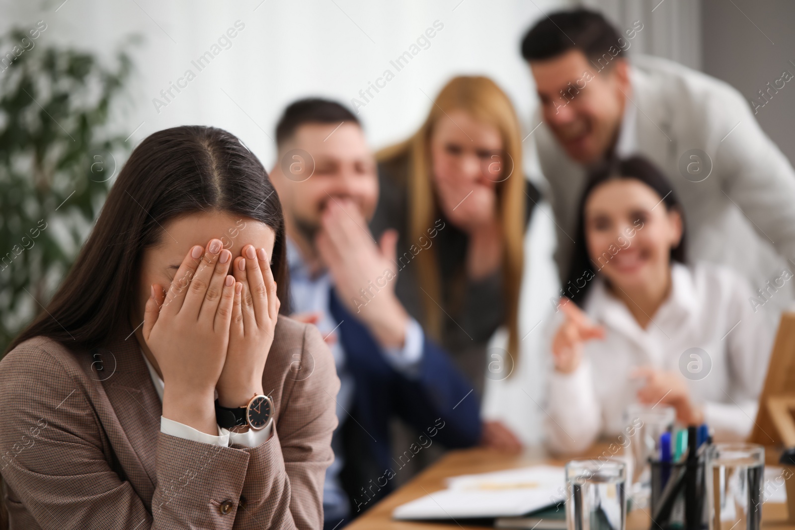 Photo of Coworkers bullying their colleague in office, space for text