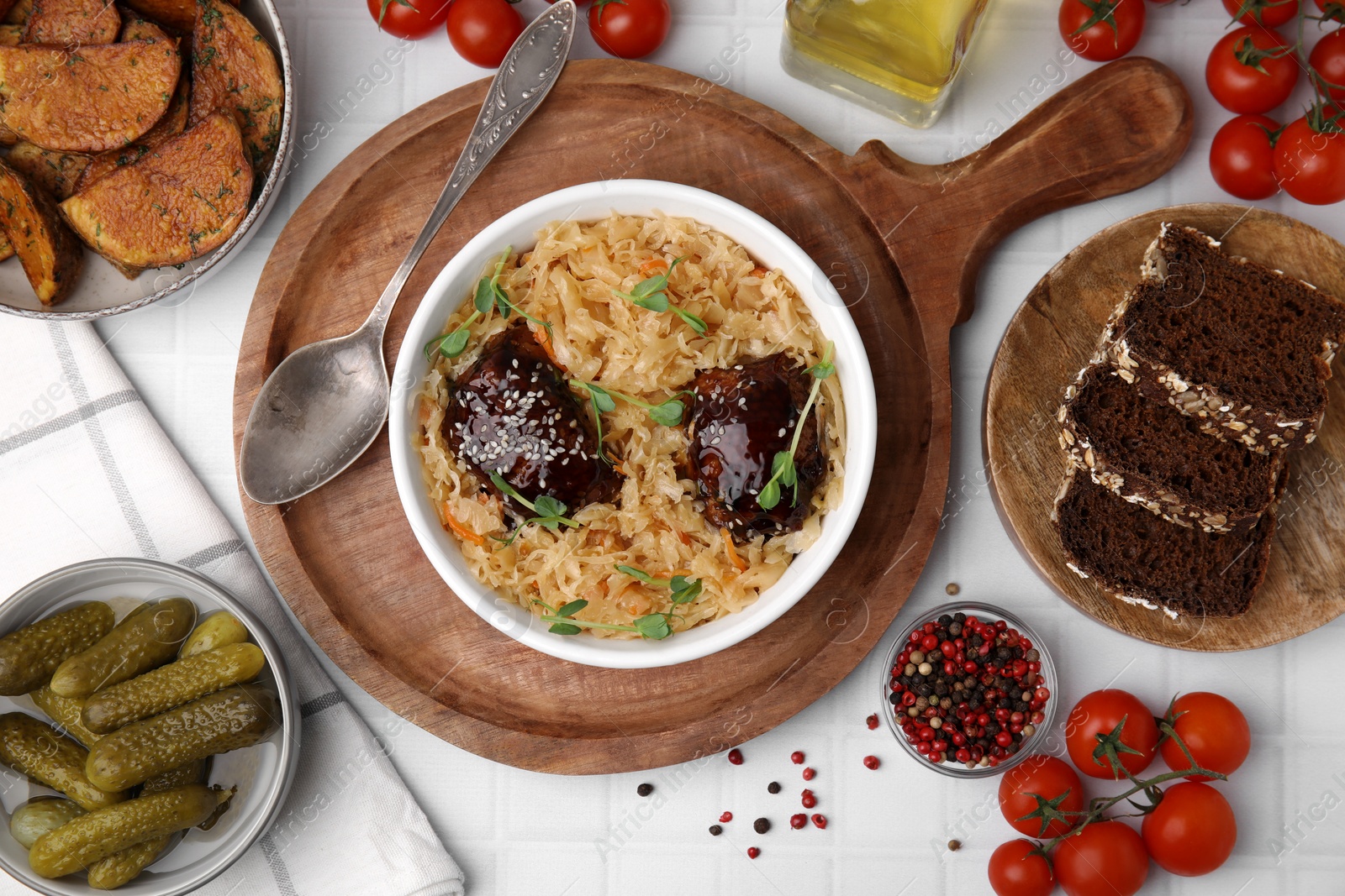 Photo of Bowl with sauerkraut and chicken served on white table, flat lay