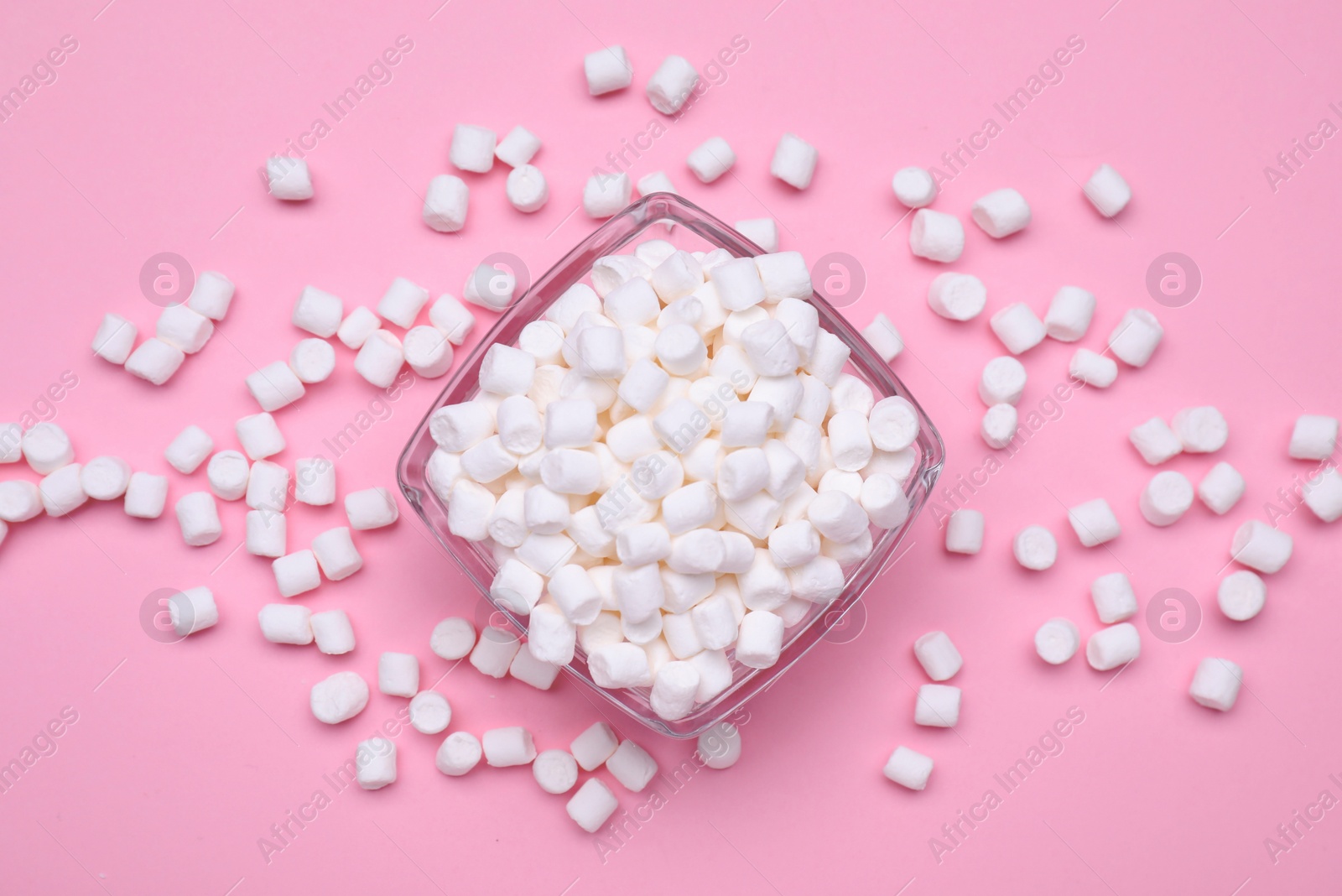 Photo of Bowl with sweet marshmallows on pink background, flat lay