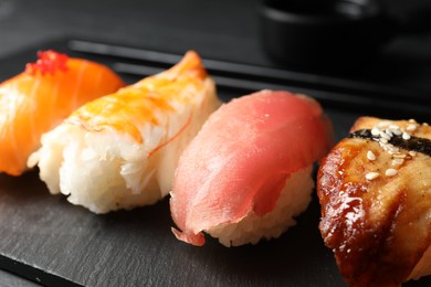Plate with delicious nigiri sushi on black table, closeup